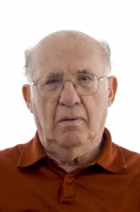 older man,elderly male, brown shirt , wearing glasses, looking solomn